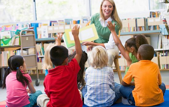 Kindergarten teacher reading to children in library Kindergarten teacher reading to children in library