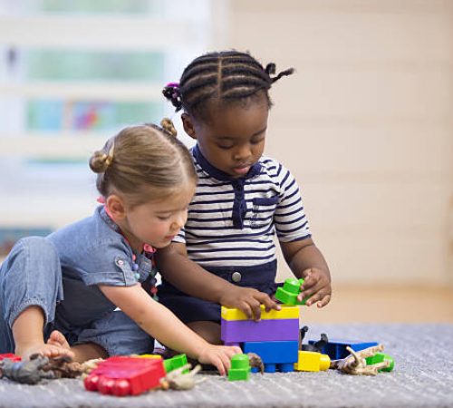 istockphoto-514561326-612x612 A multi-ethnic group of preschoolers are playing with plastic blocks together in class.